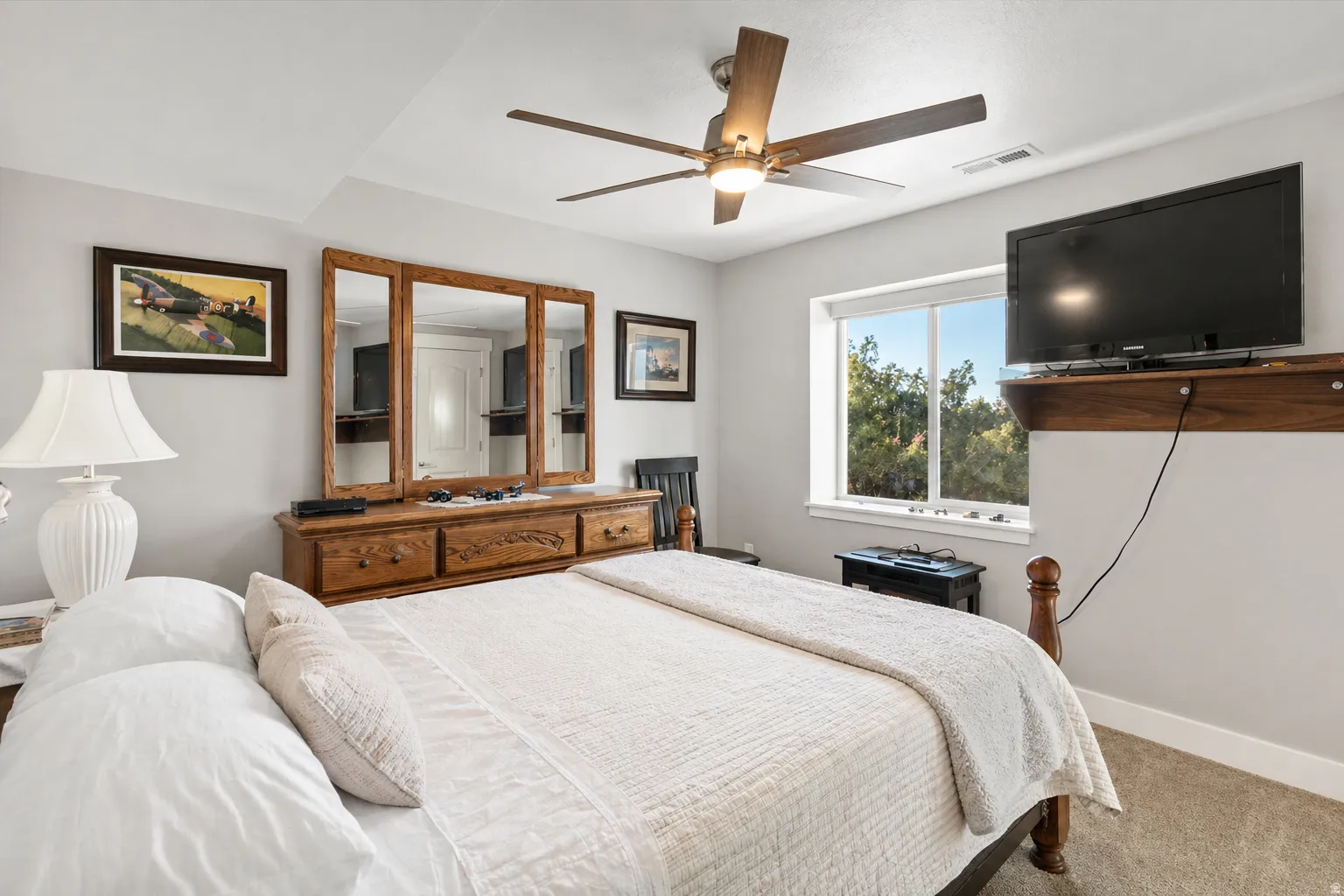 Carpeted basement bedroom 2 featuring a ceiling fan and baseboards