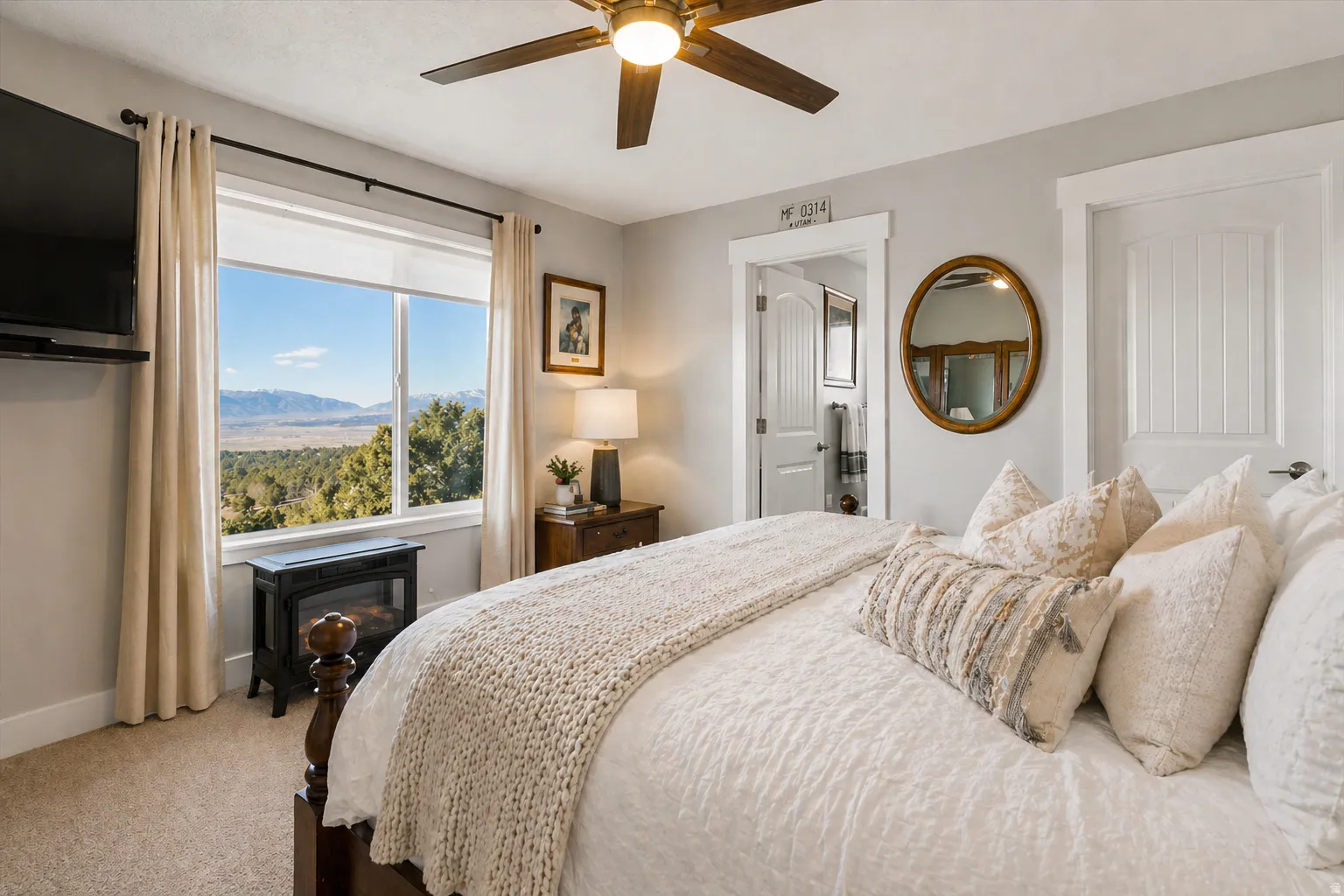 Carpeted bedroom featuring a ceiling fan and a mountain view