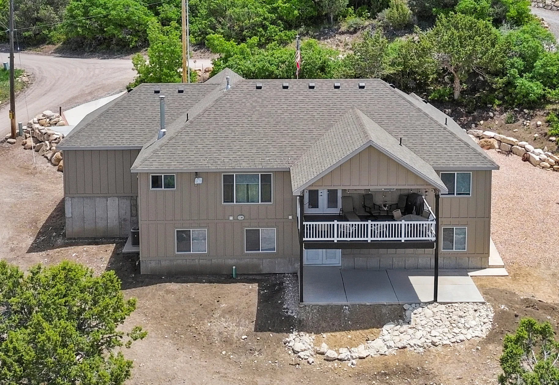 Back of house featuring a shingled roof and a deck