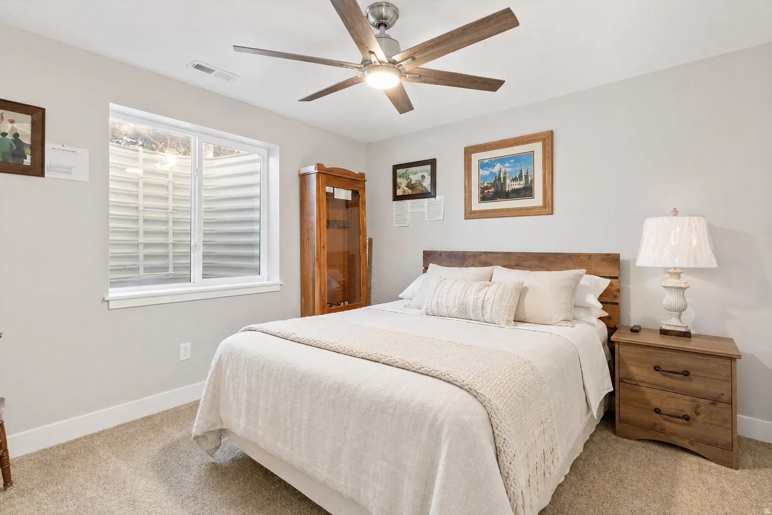 Basement Bedroom 1 featuring a ceiling fan and light colored carpet