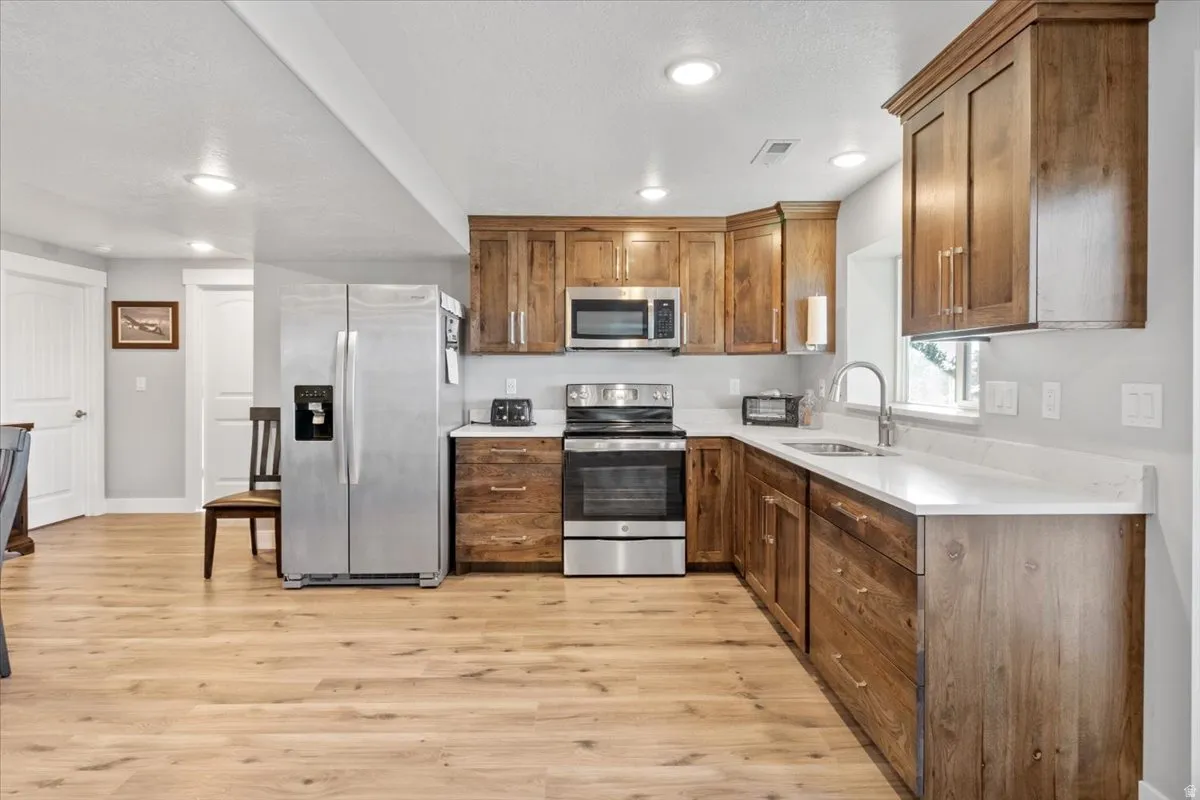 Kitchen featuring stainless steel appliances, recessed lighting, light wood finished floors, and wood finish cabinetry