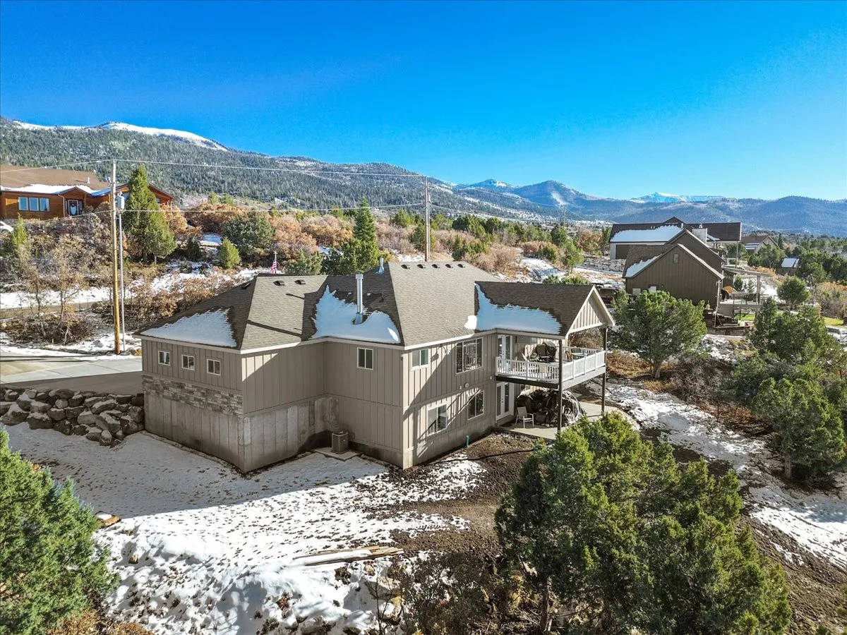 Snowy aerial view with a mountain view and a residential view