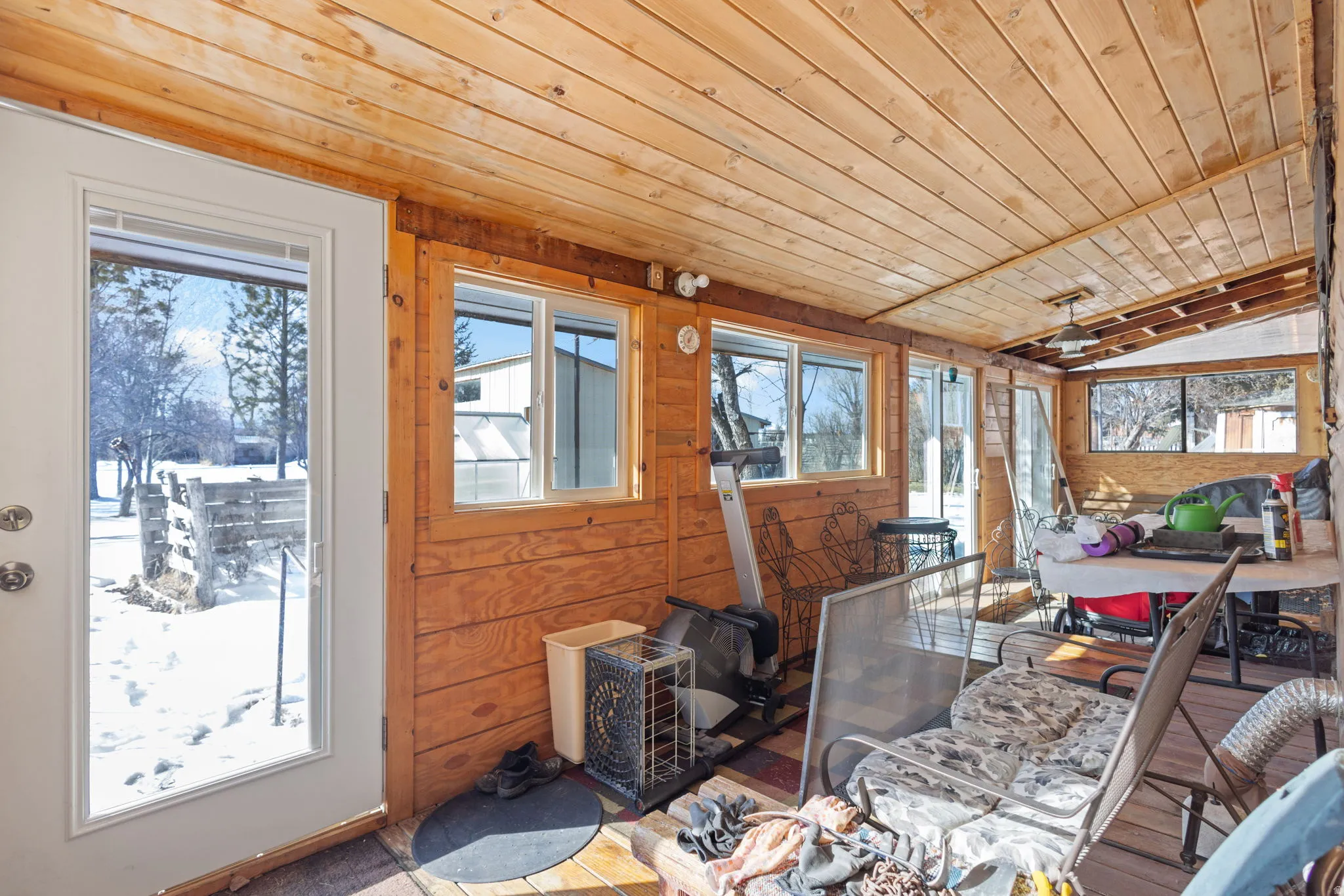Sunroom featuring wood walls and a vaulted wooden ceiling