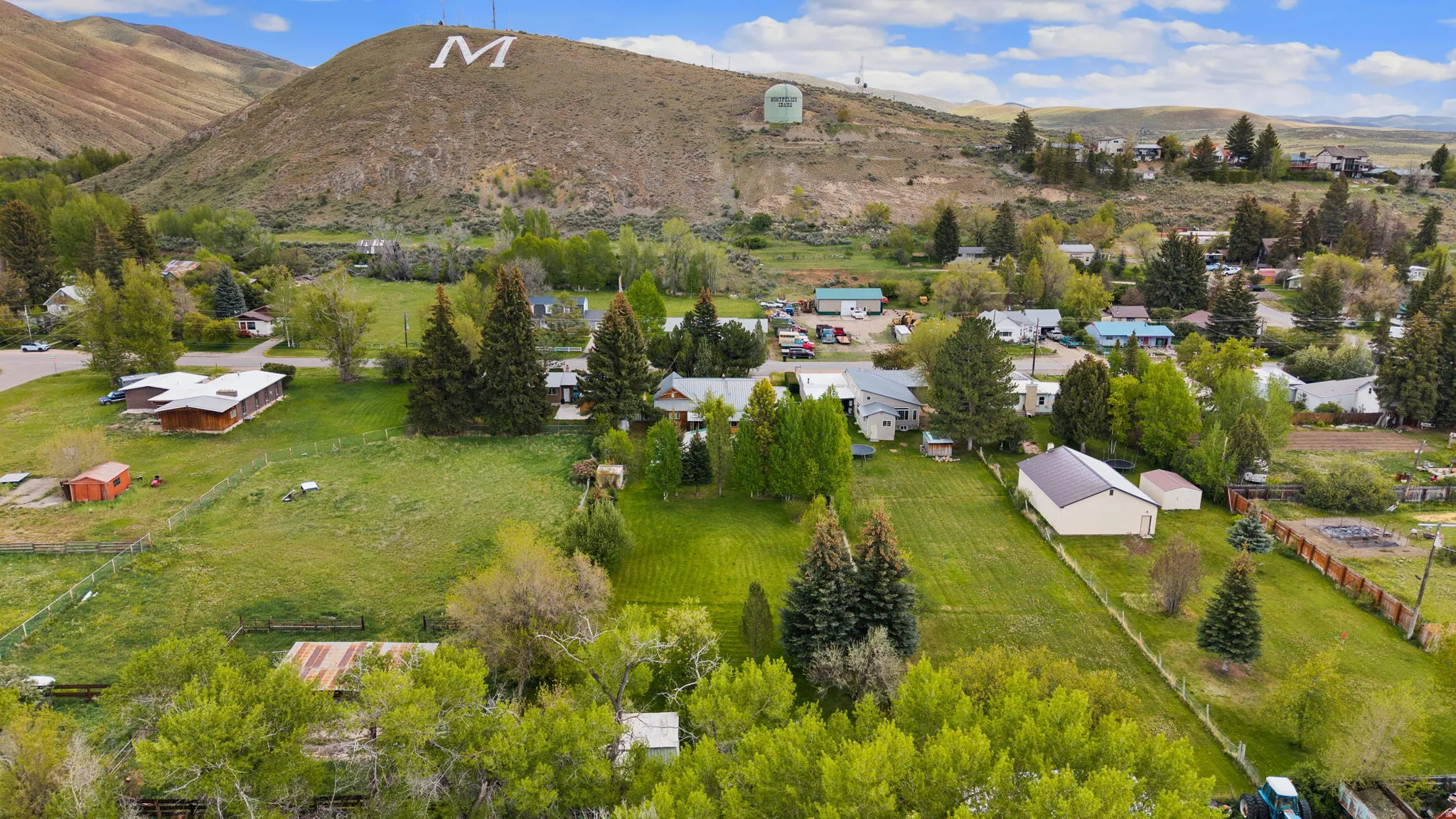 Aerial view of a residential area set against a hillside with an "M" emblazoned