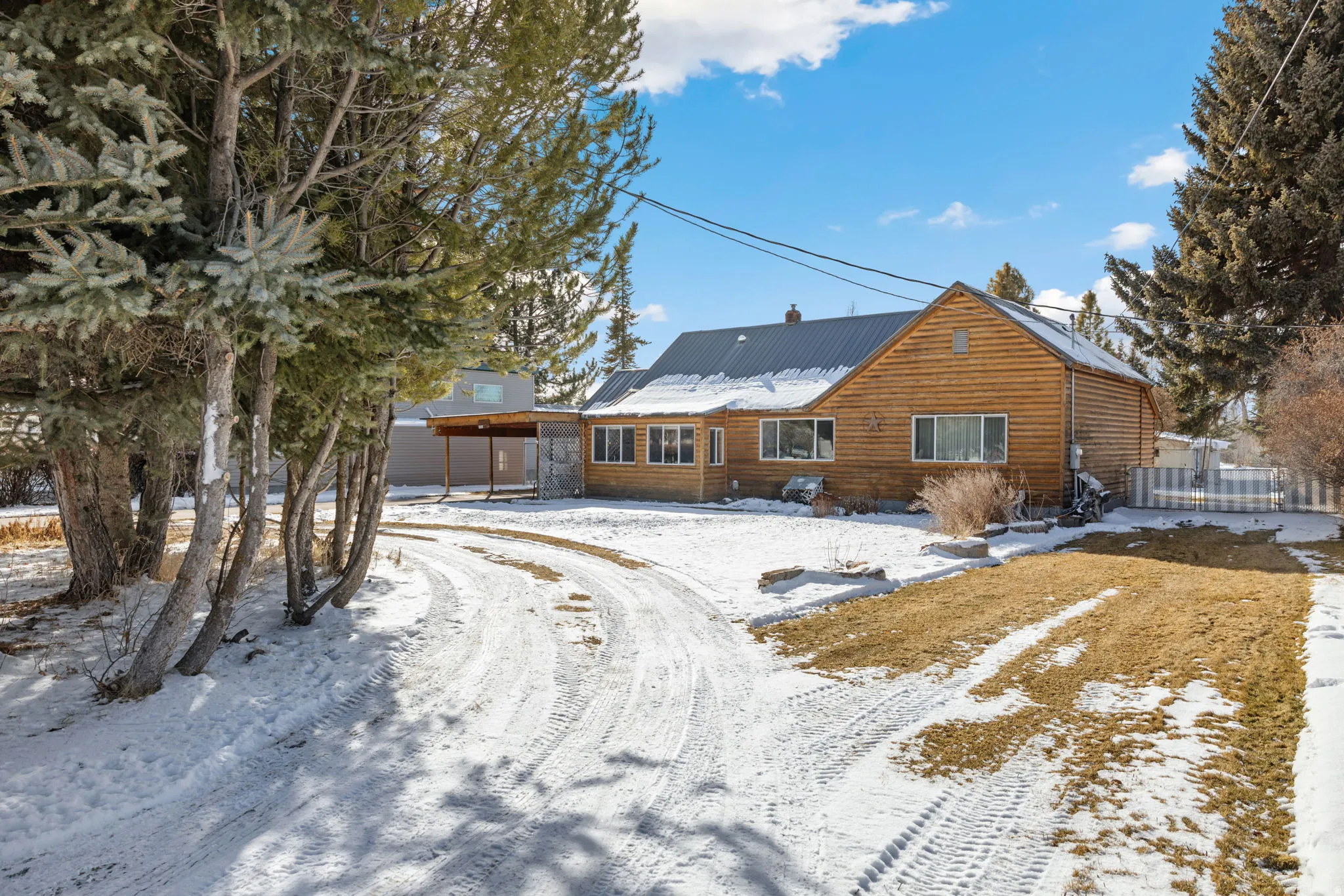 Snow covered rear of property with a metal roof