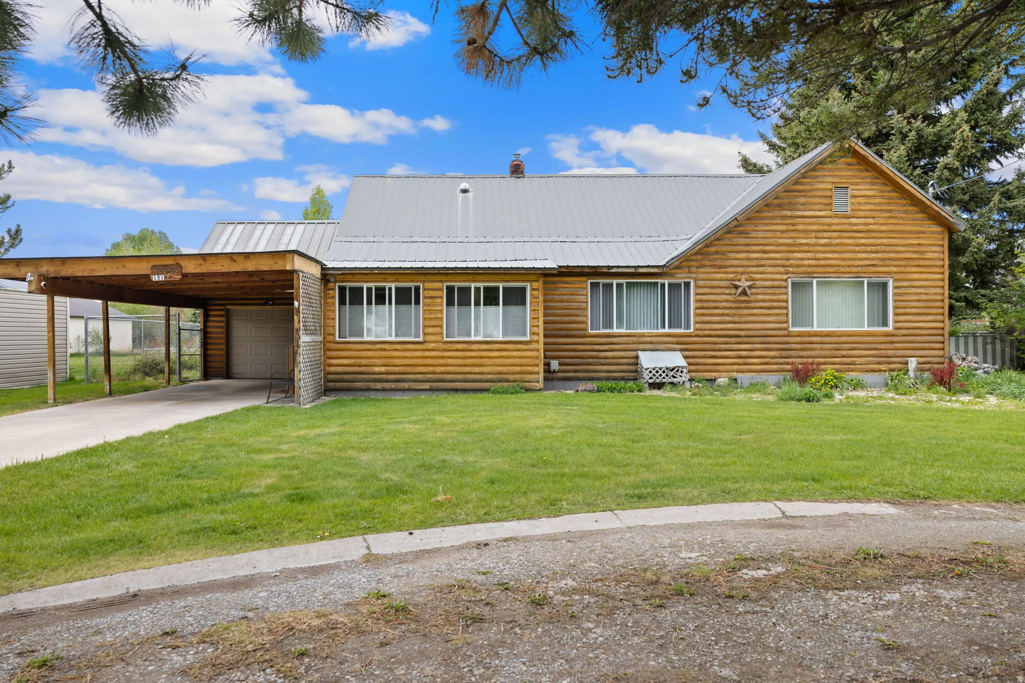 Log cabin style home featuring a metal roof and a spacious front lawn