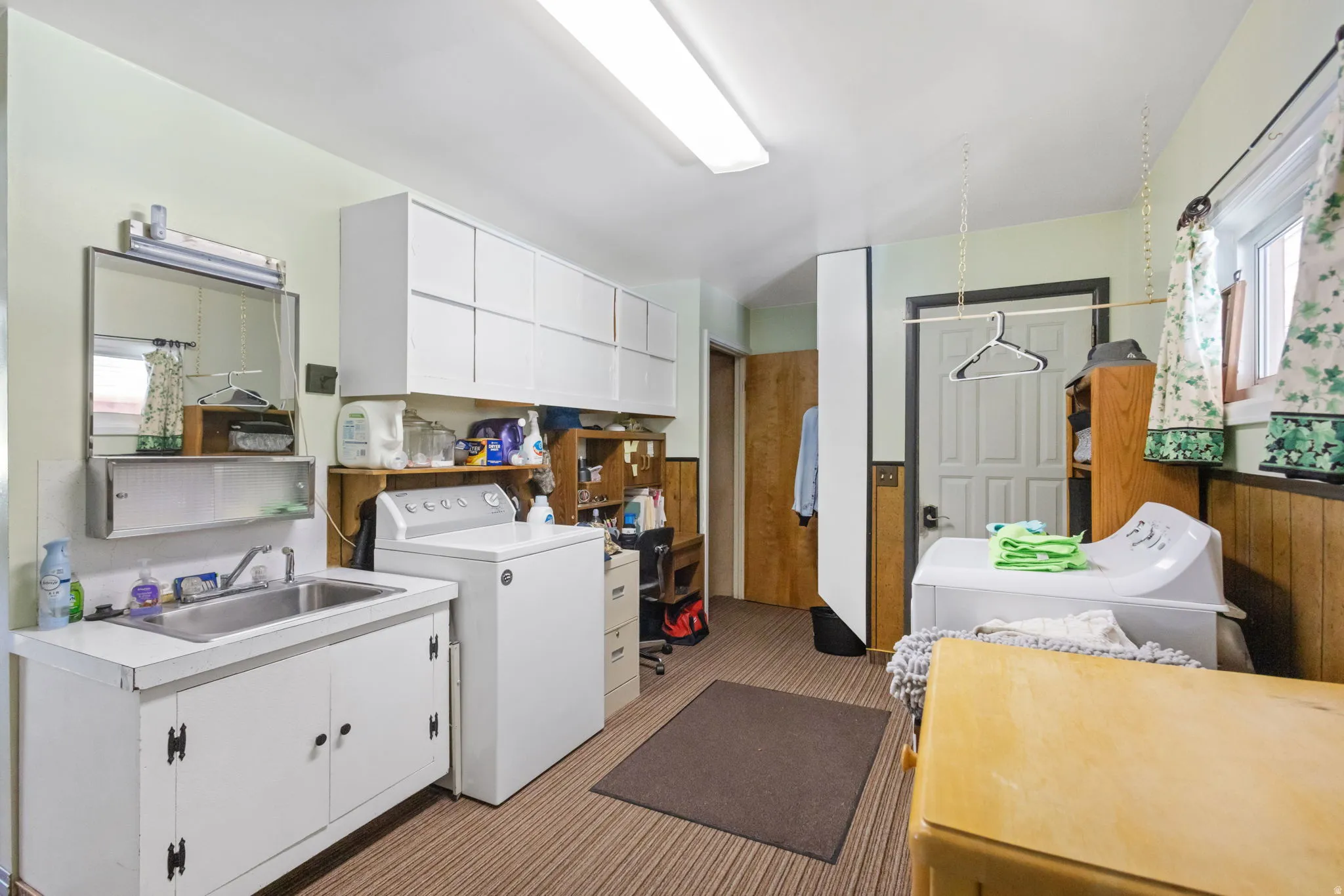 Laundry area featuring cabinet space, light colored carpet, and washer and clothes dryer