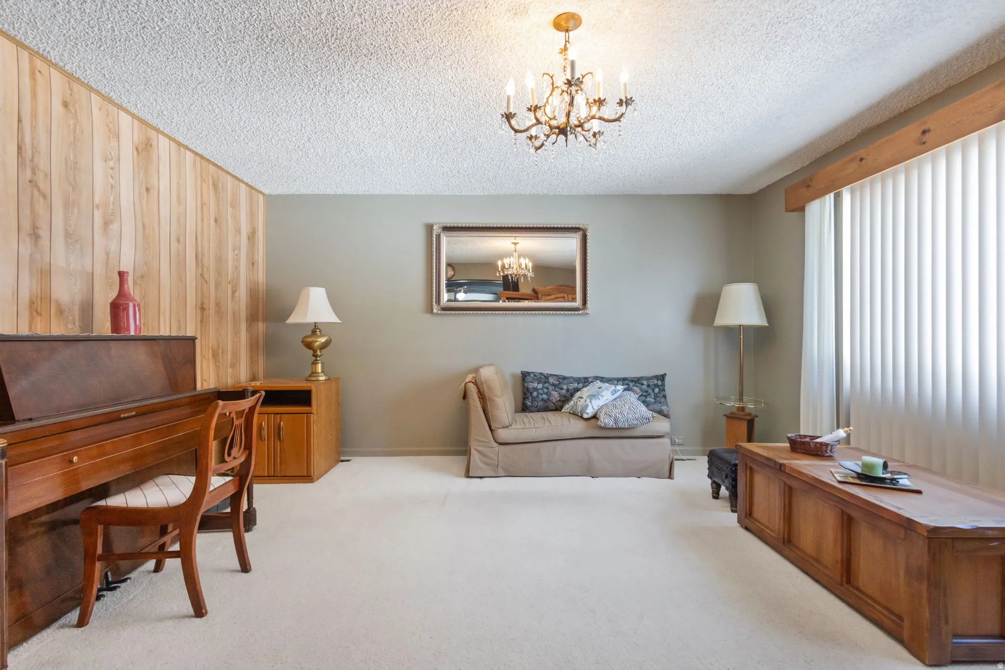 Carpeted home office with suspended lighting, wood walls, and a textured ceiling