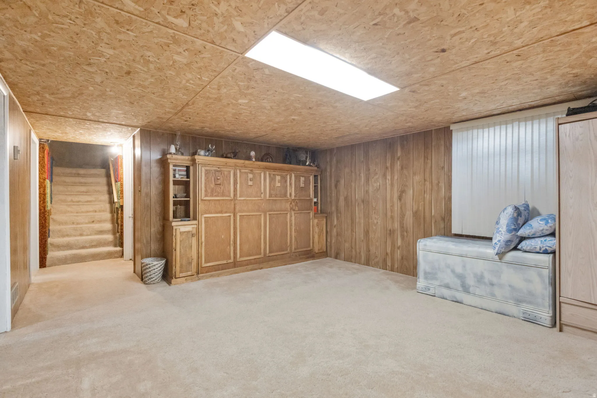Finished basement featuring light carpet and wood walls