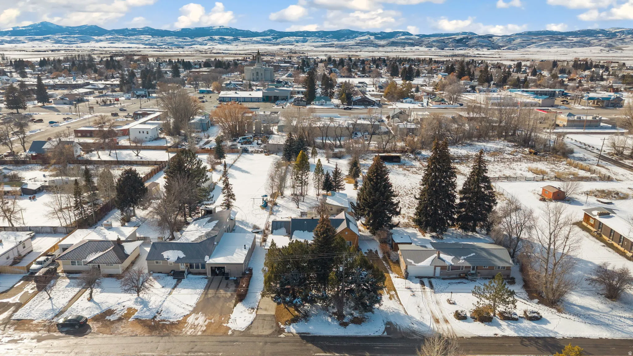 Snowy aerial view with a mountain view and a residential view