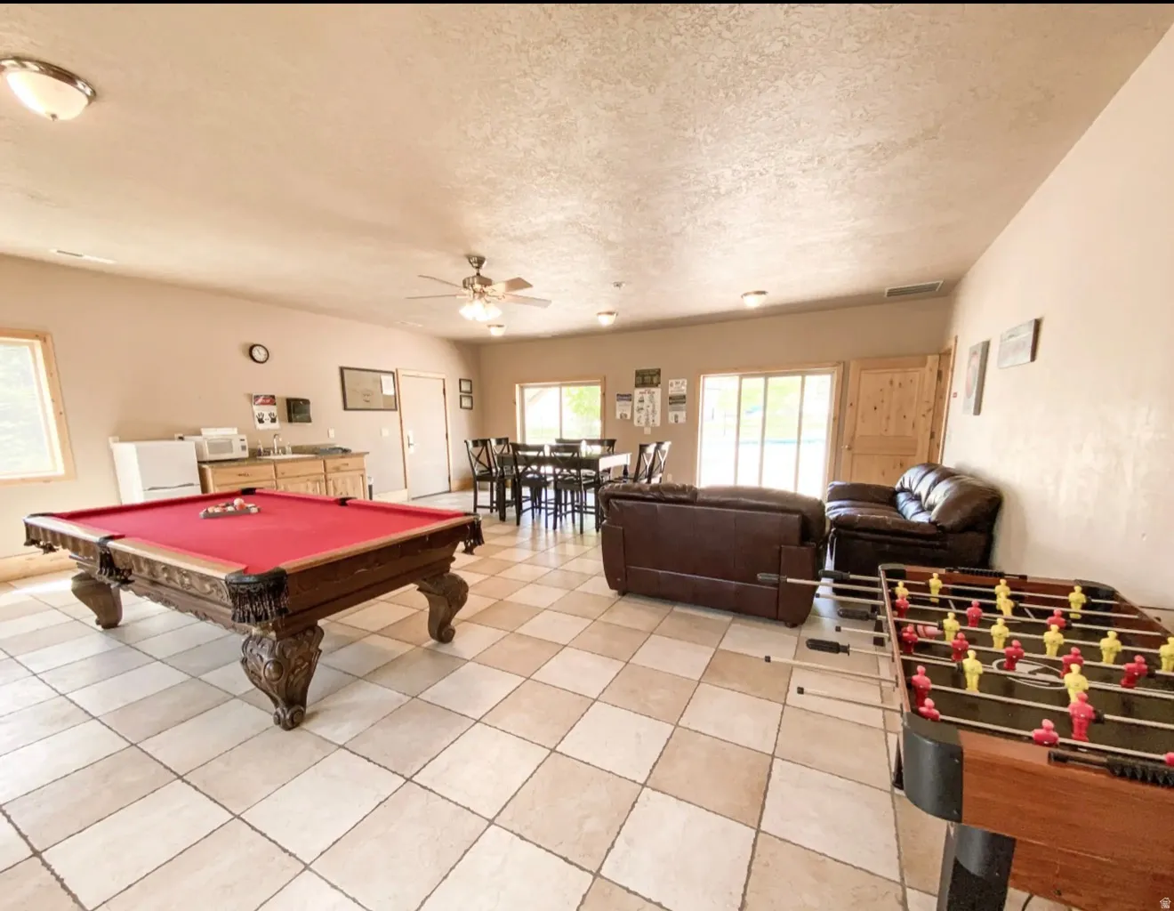Game room with pool table, ceiling fan, a textured ceiling, and light tile patterned flooring