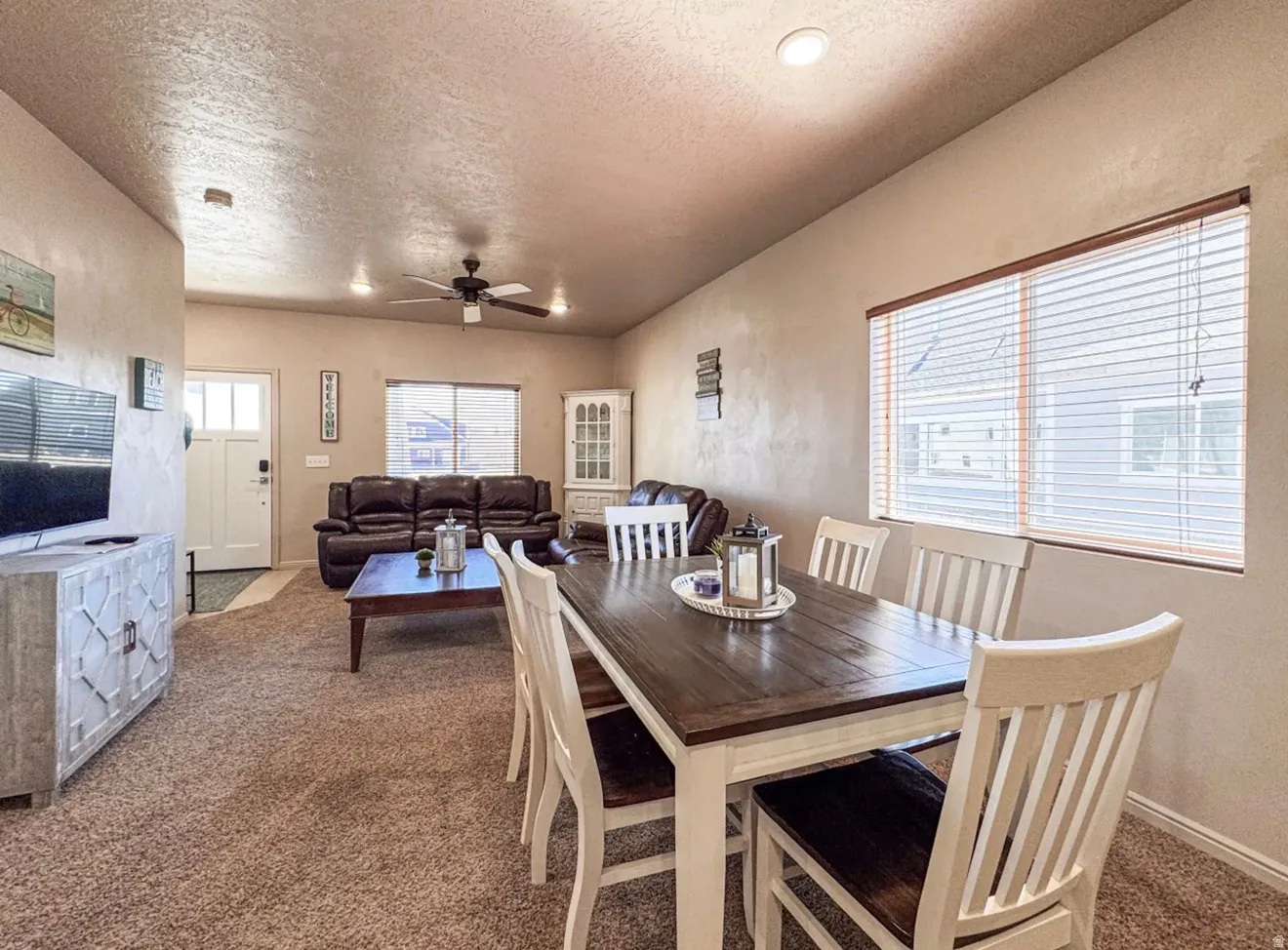 Dining room featuring carpet, ceiling fan, and a textured ceiling