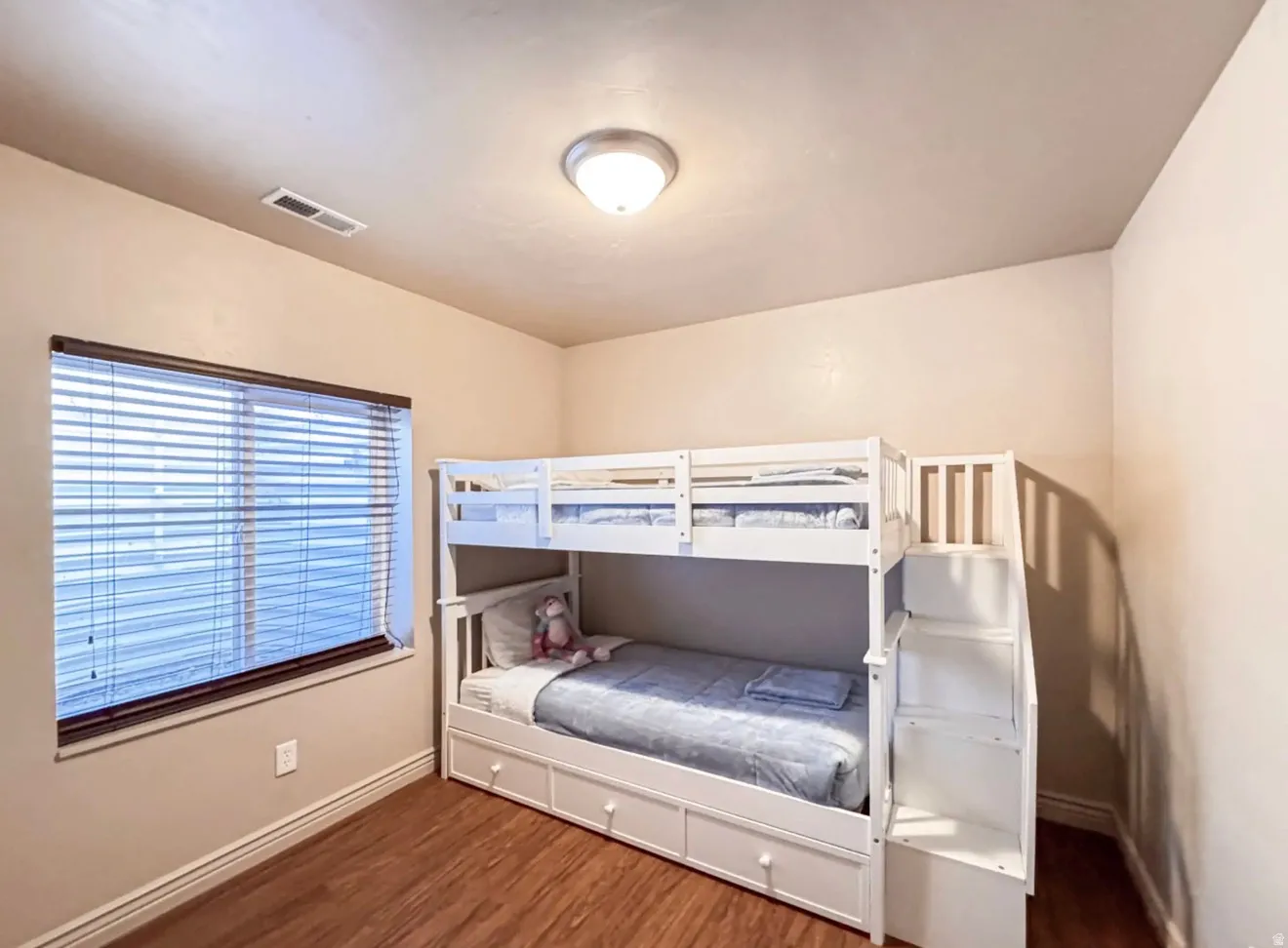 Bedroom with dark wood finished floors and baseboards