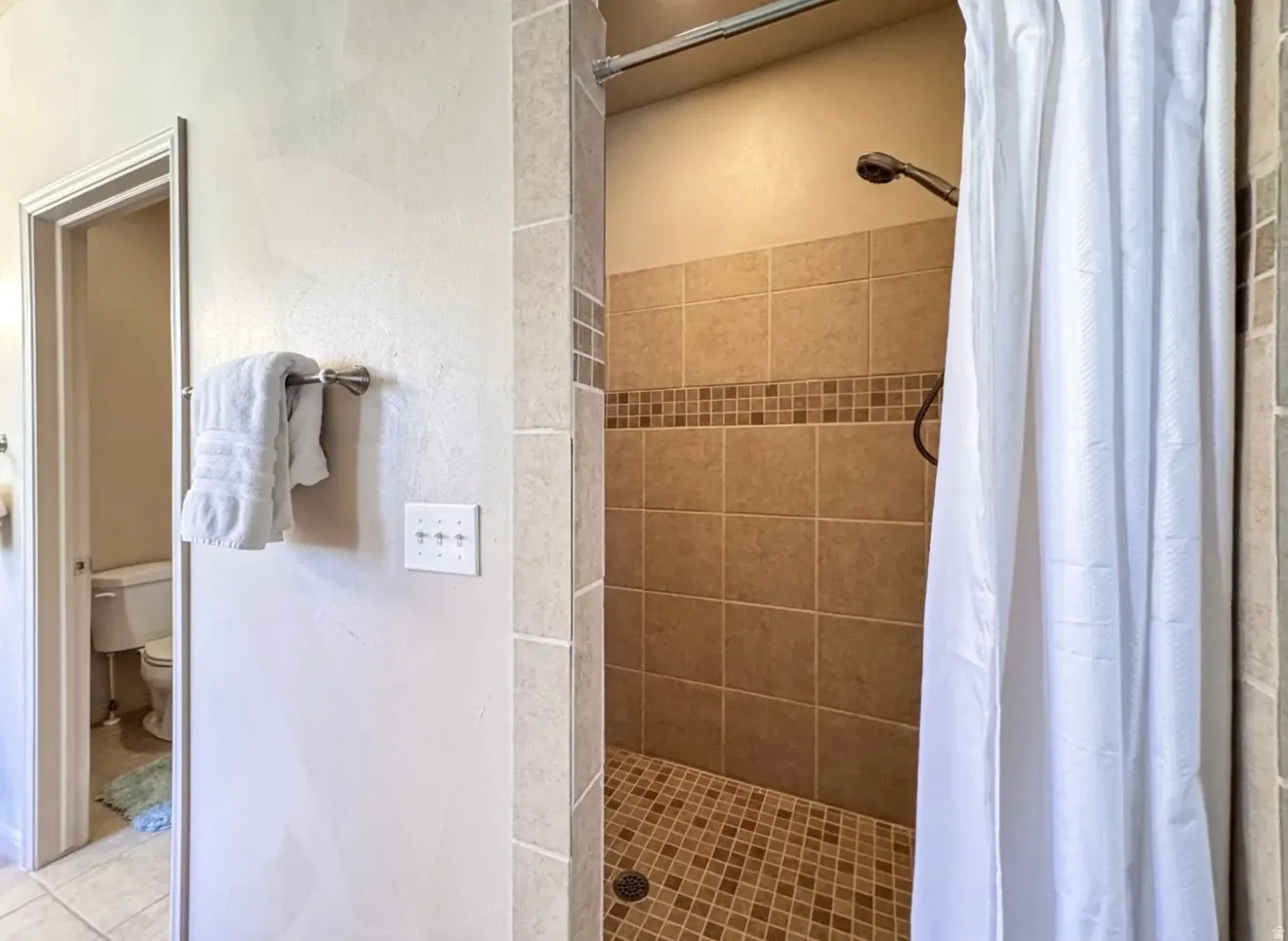 Bathroom with a shower stall and toilet