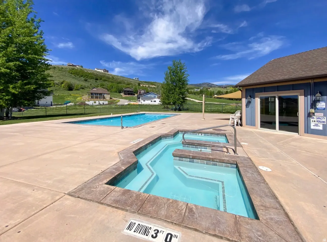 Community pool with a patio area, a hot tub, and a mountain view