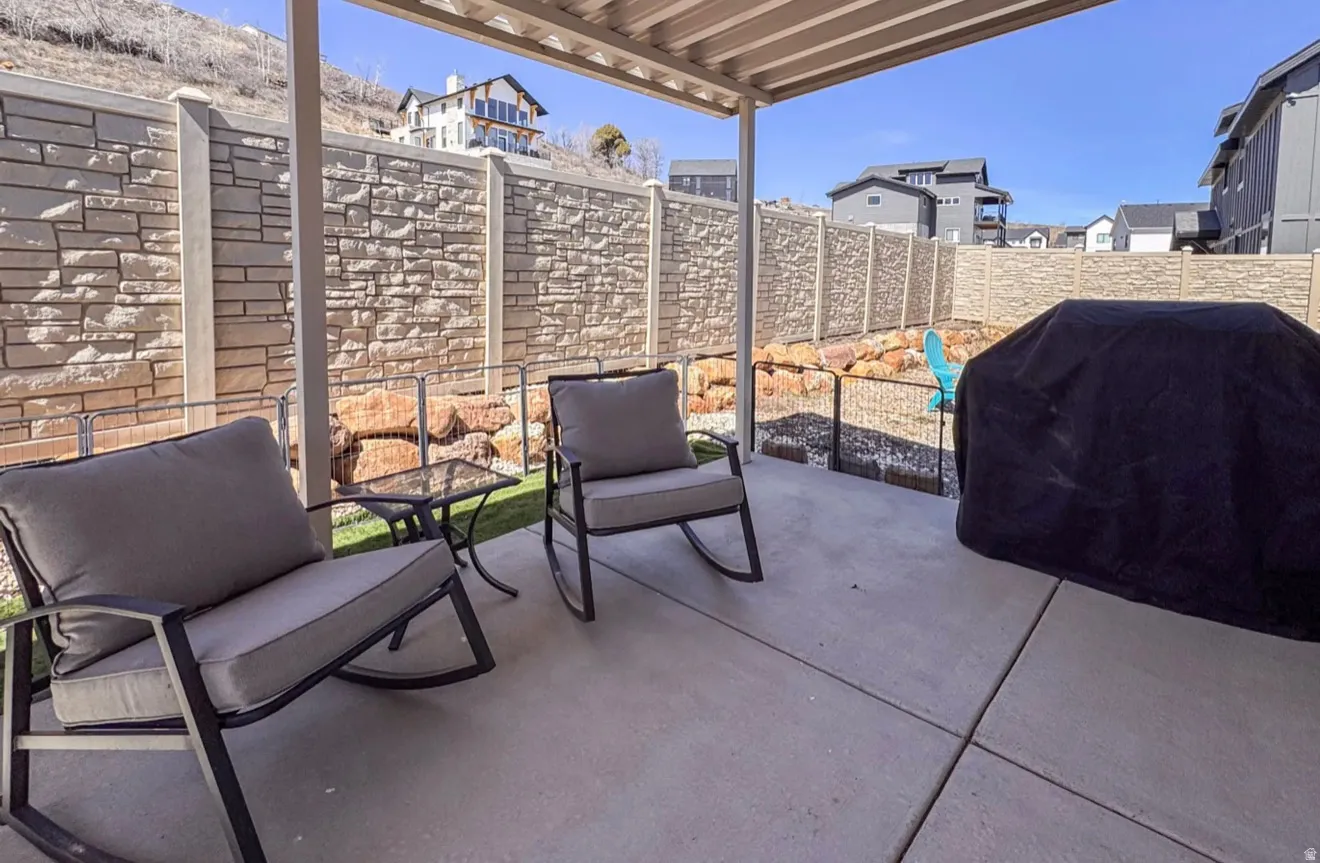 Fenced backyard with a patio area and a grill