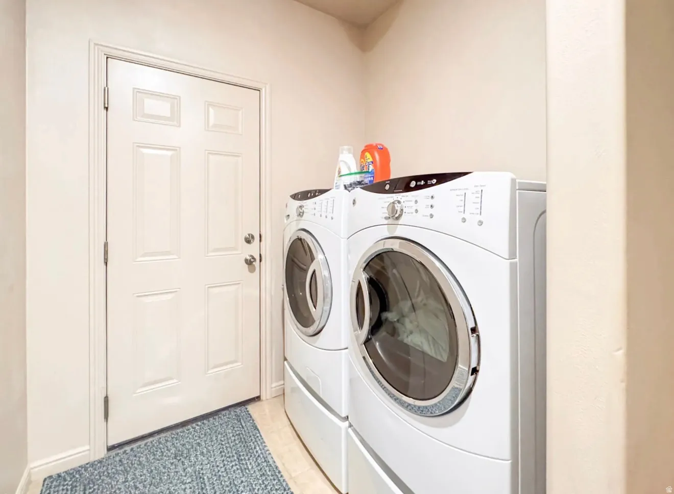 Laundry area featuring washer and dryer and light tile patterned floors