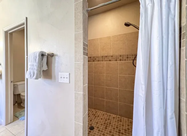 Bathroom with a shower stall and toilet