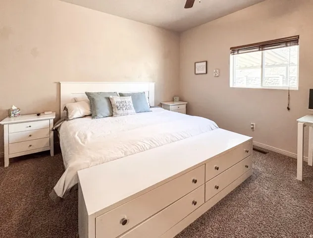 Bedroom featuring dark carpet and a ceiling fan