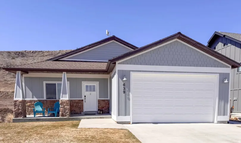 View of front of house featuring a porch, a garage, concrete driveway, a shingled roof, and stone siding