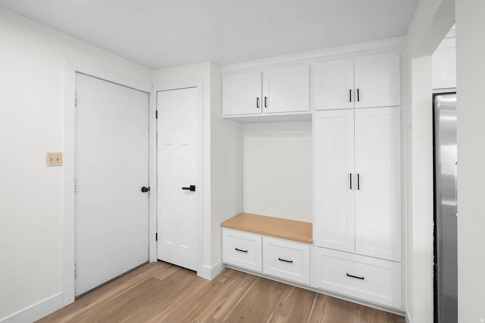 Mudroom with light wood-type flooring and baseboards