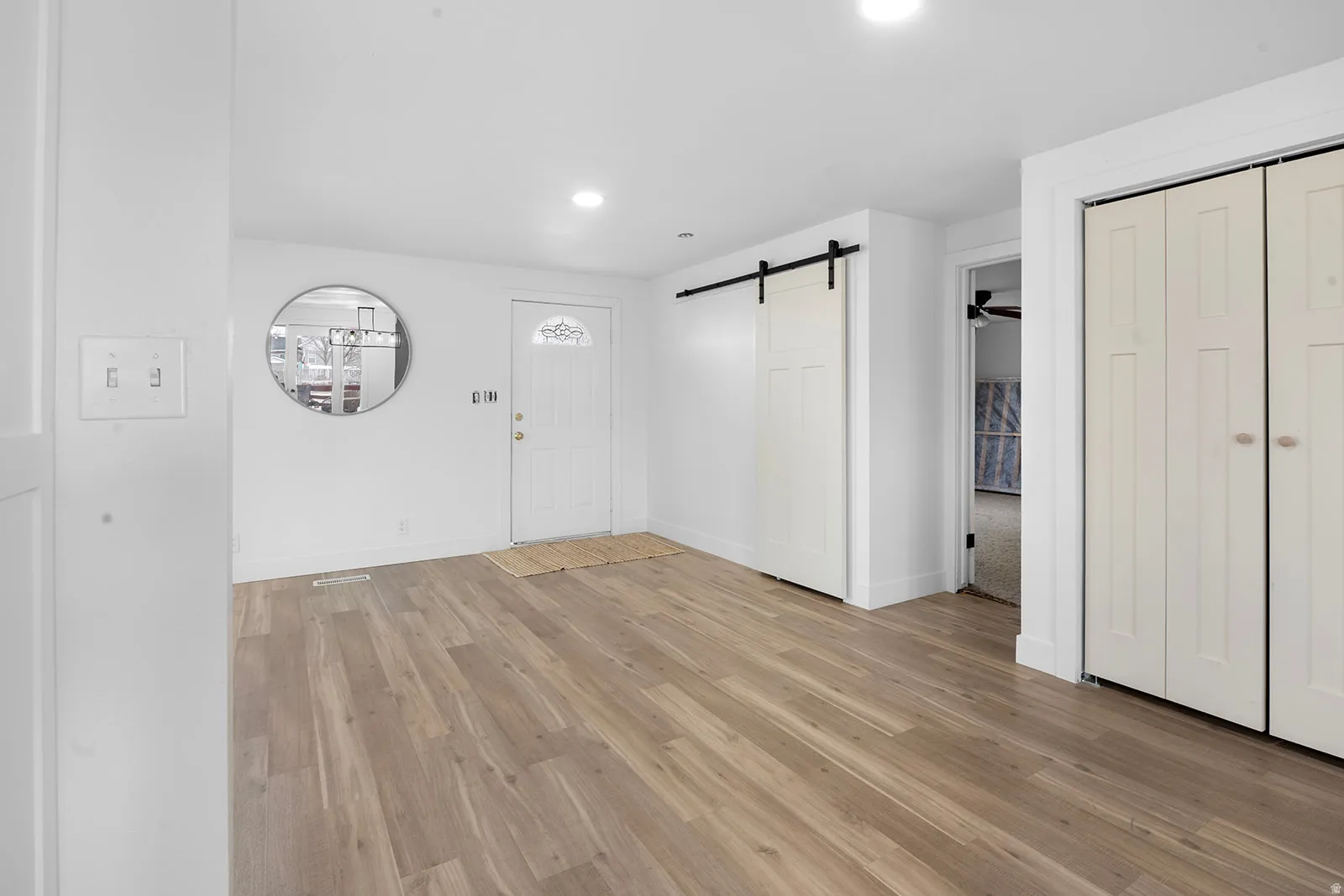 Foyer entrance with a barn door, light wood-style flooring, recessed lighting, and a ceiling fan