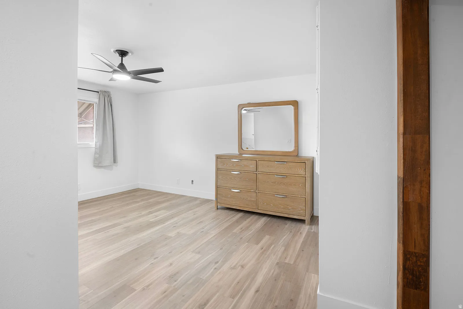 Unfurnished bedroom featuring ceiling fan and light wood-style flooring