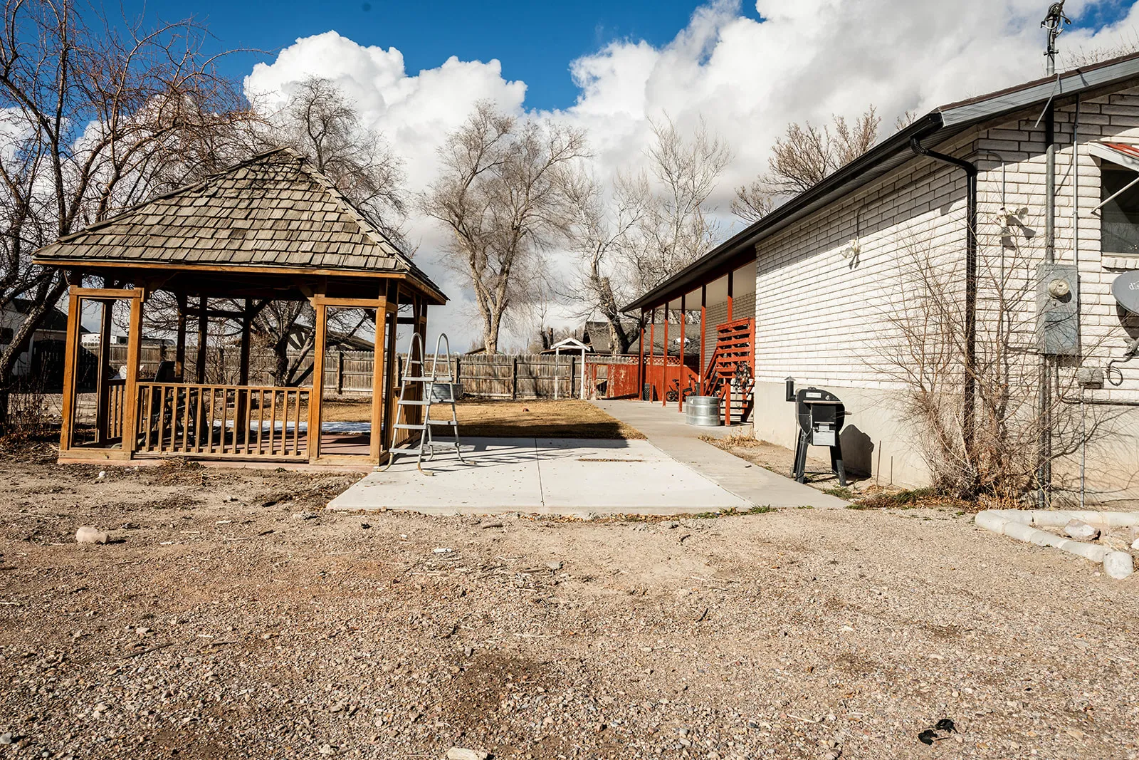 Fenced yard featuring a gazebo and a patio