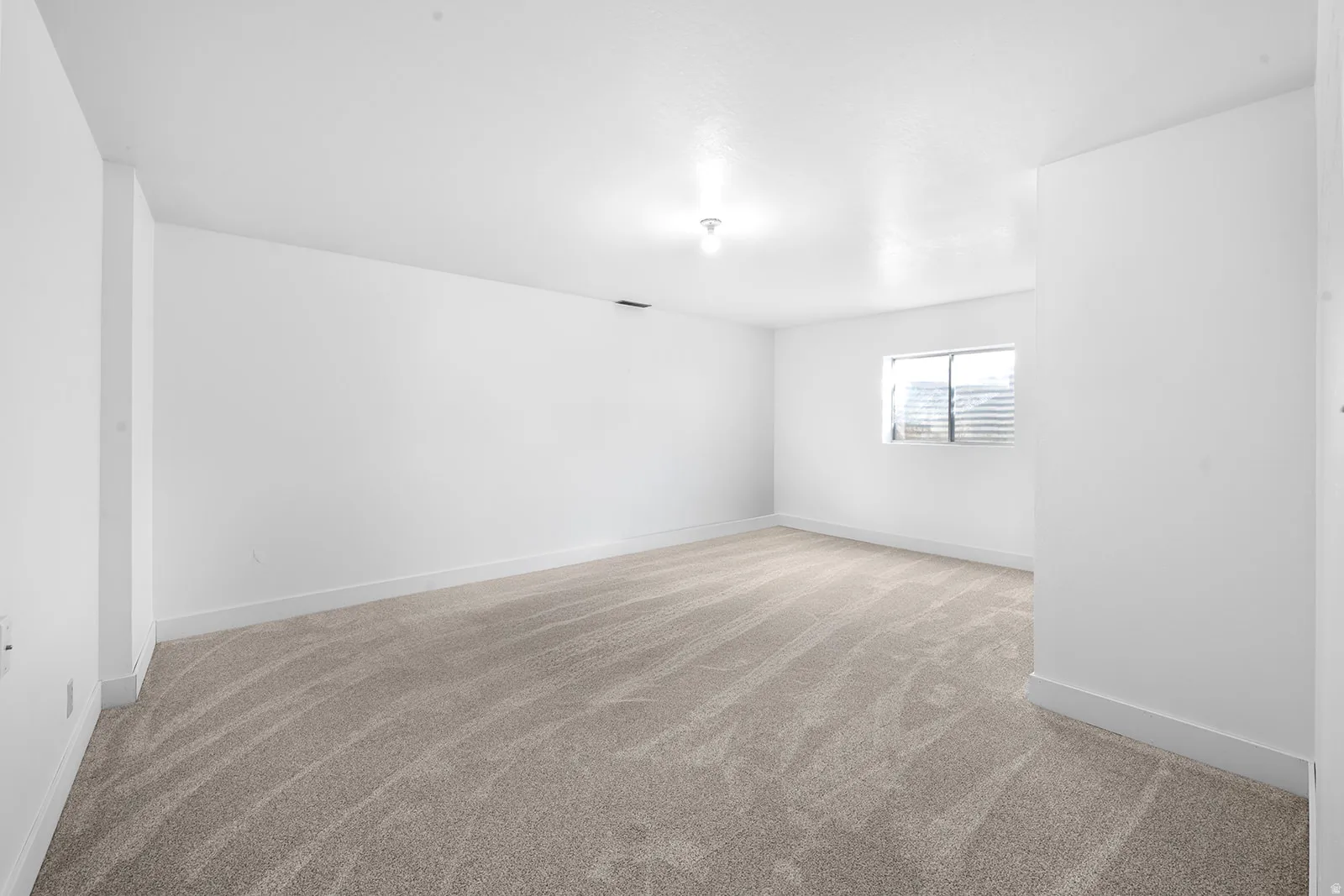 Unfurnished room with light carpet and baseboards