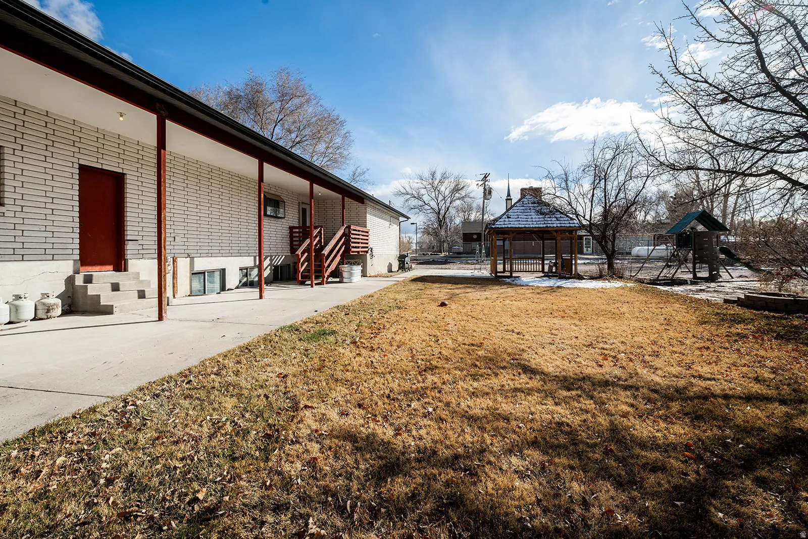 View of grassy yard with a gazebo, a patio area, and entry steps