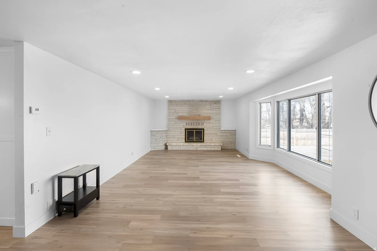 Unfurnished living room with light wood-style flooring, recessed lighting, and a fireplace