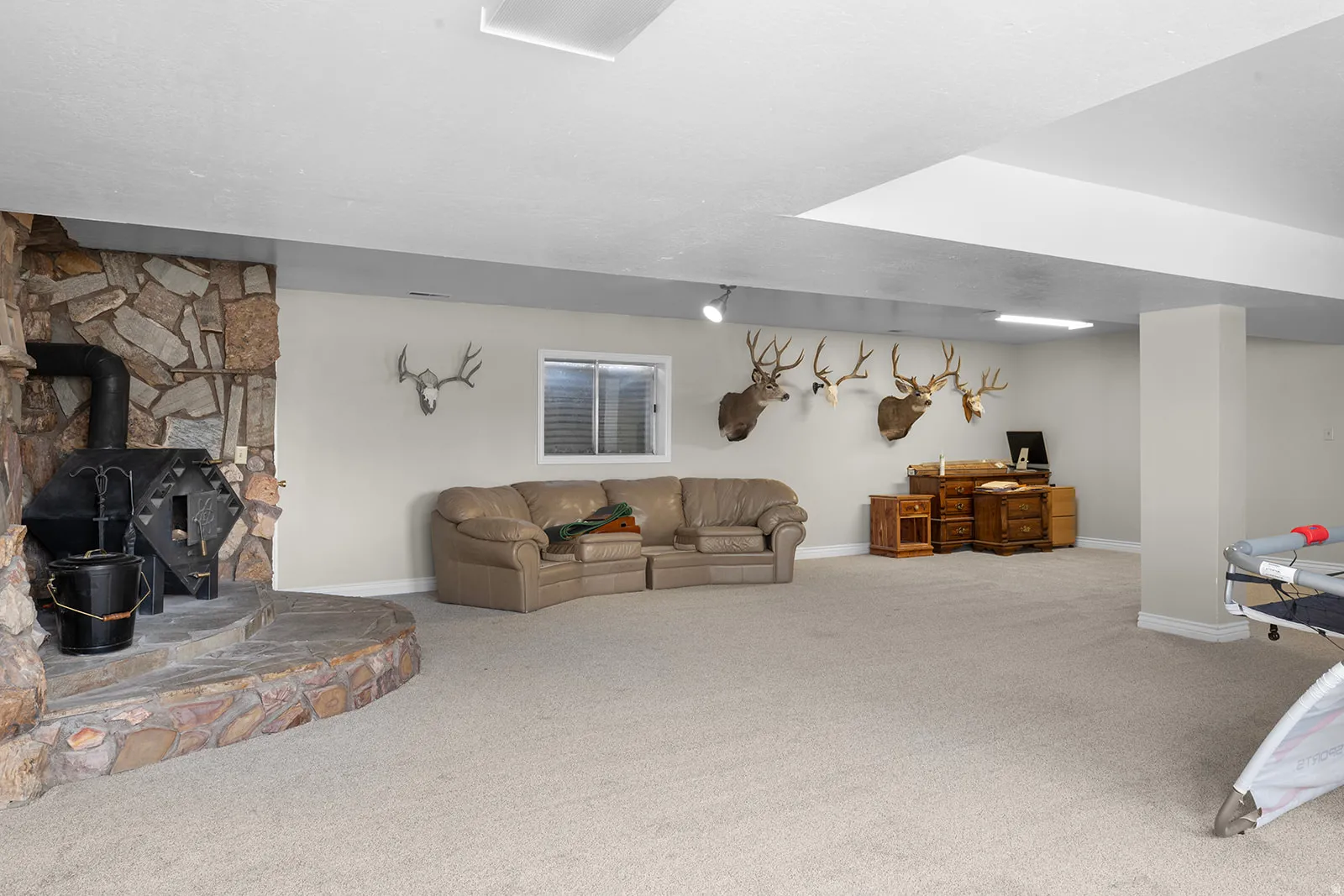 Carpeted living area with a wood stove and an office area