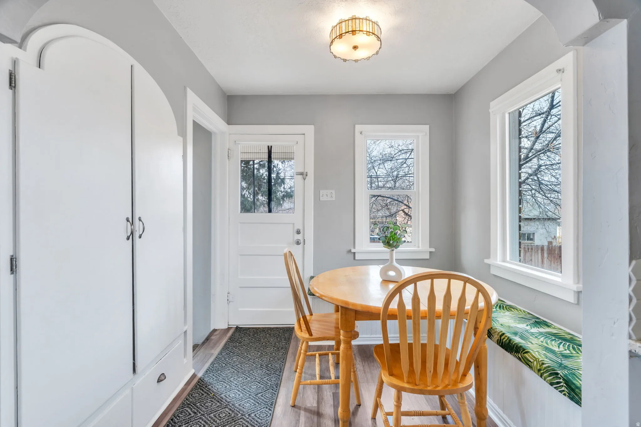 Dining room featuring arched walkways and dark wood-style flooring