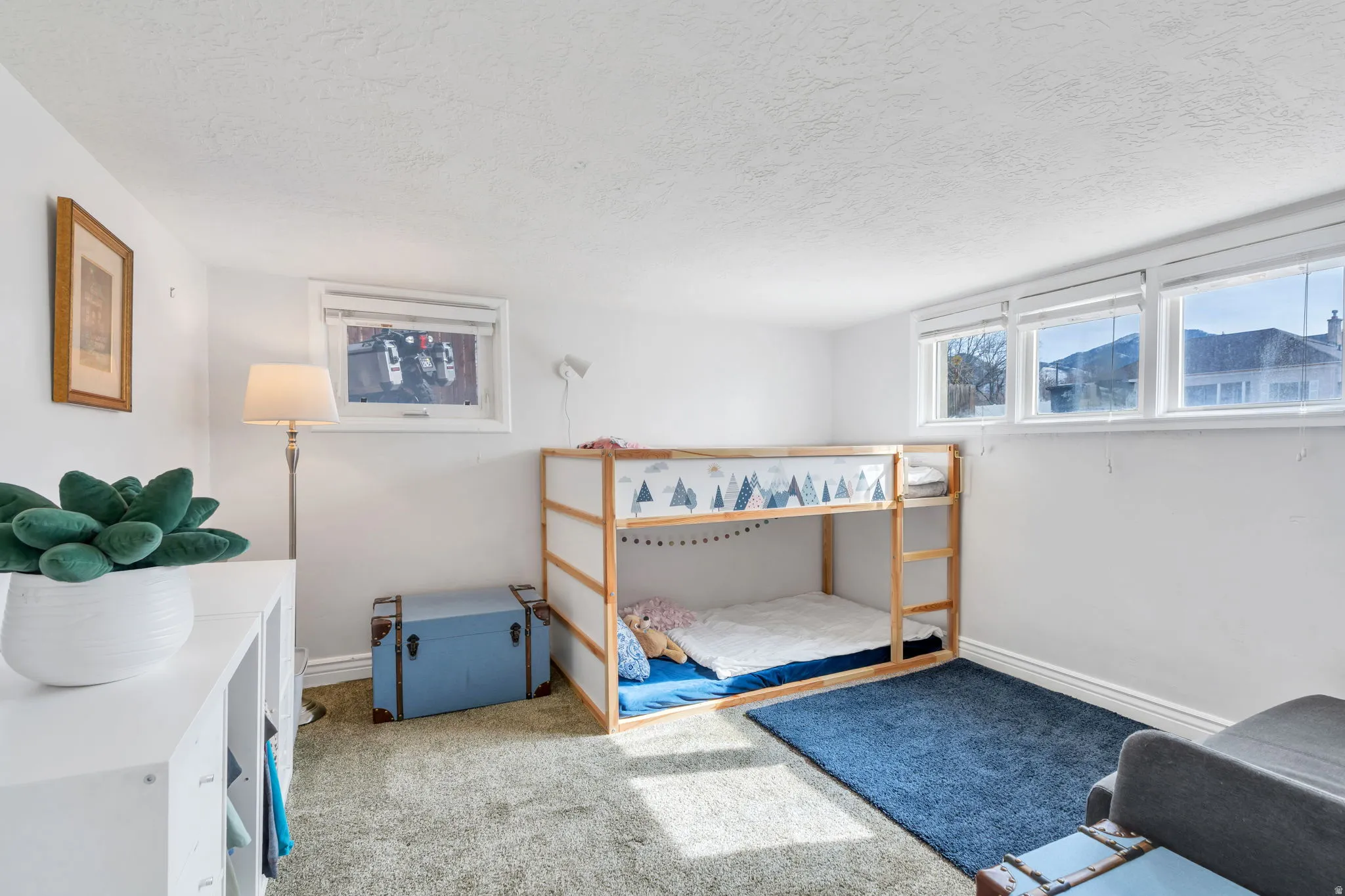 Carpeted bedroom with a textured ceiling and baseboards