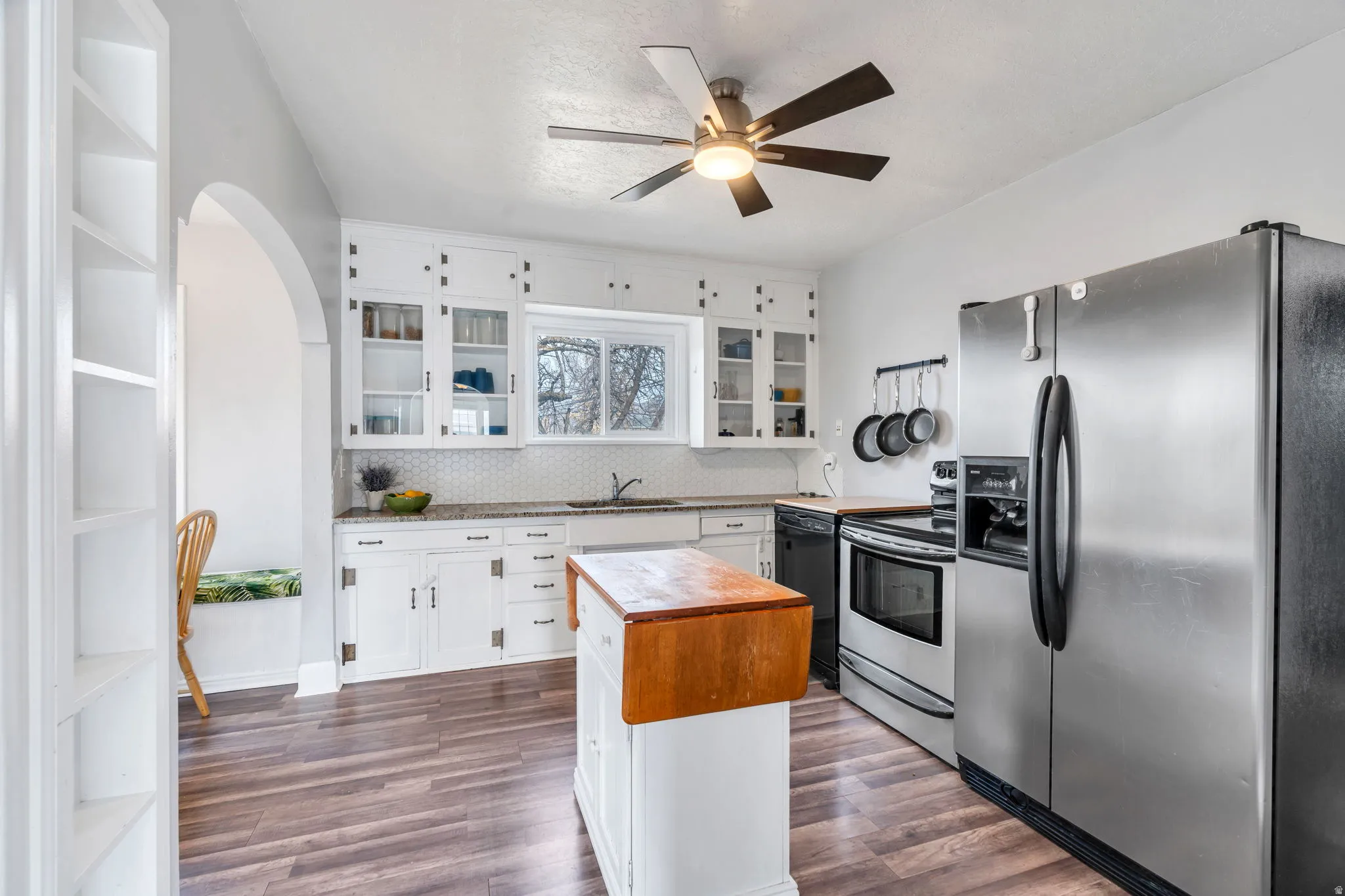Kitchen featuring stainless steel appliances, white cabinetry, glass fronted cabinets, and dark wood-type flooring