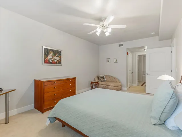 Bedroom with light carpet and a ceiling fan