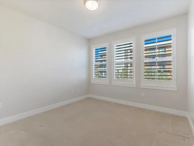 Spare room featuring baseboards and light carpet