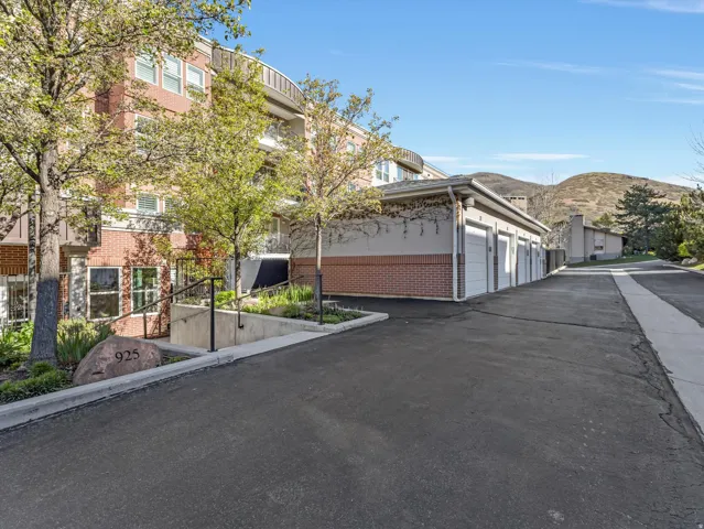 View of asphalt road featuring a mountain view and community garages