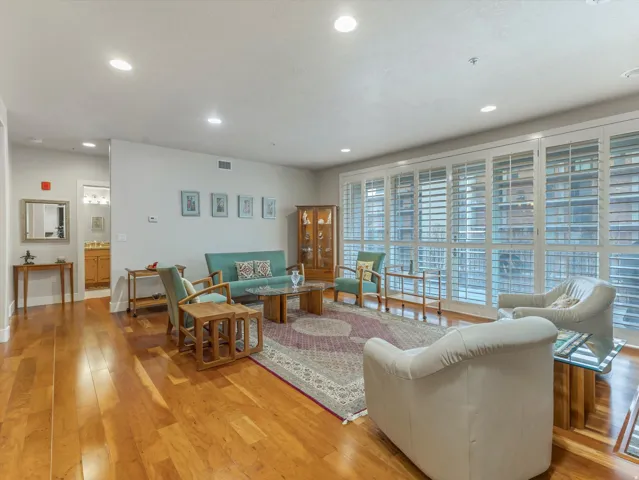 Living area with light wood-type flooring and recessed lighting.