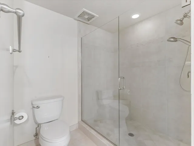 Bathroom featuring a stall shower, tile patterned floors, and recessed lighting