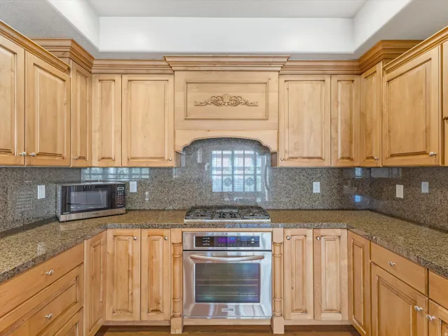 Kitchen with stainless steel appliances, tasteful backsplash, and light wood finish cabinets