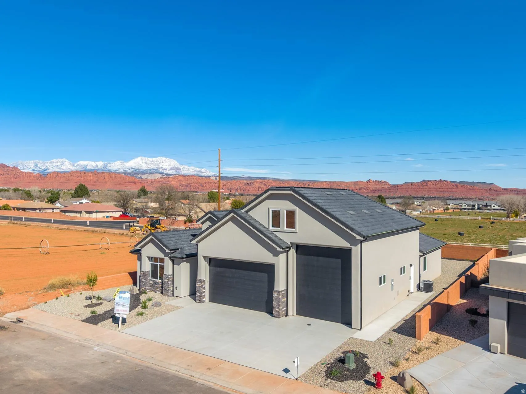 View of front of house with a mountain view, stucco siding, concrete driveway, stone siding, and an attached garage