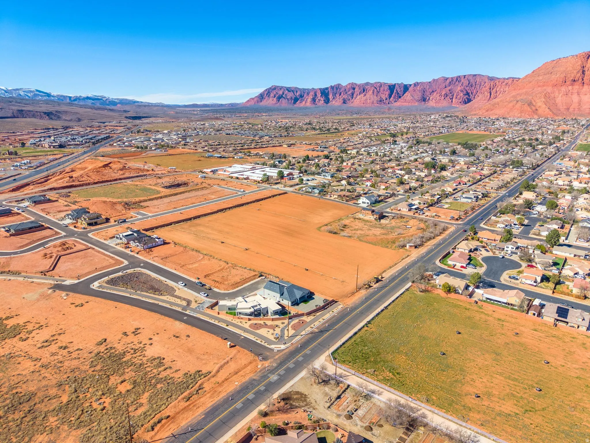 Aerial view of property and surrounding area featuring a mountain backdrop and nearby suburban area