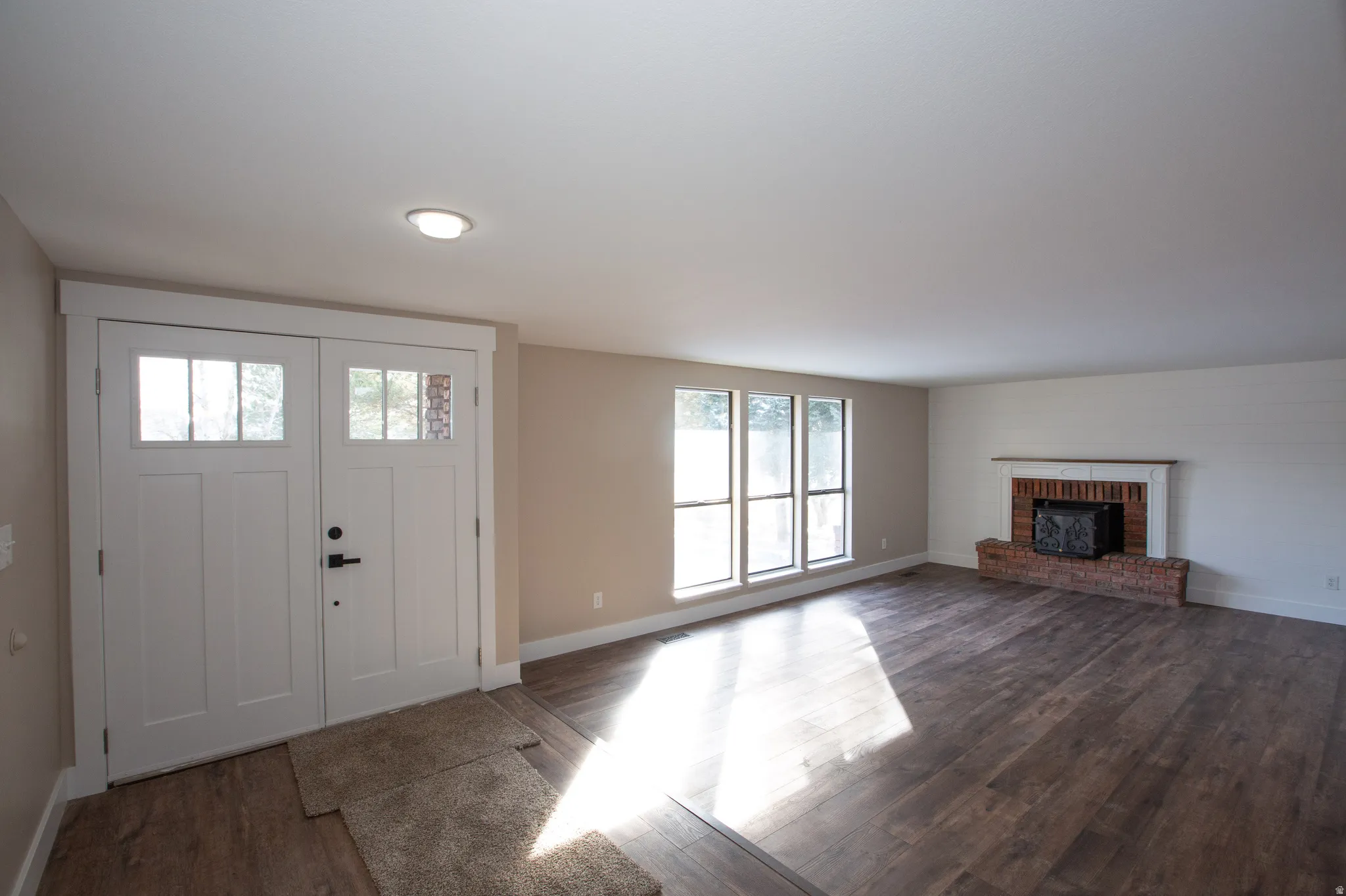 Entrance foyer featuring dark LVP flooring and a fireplace