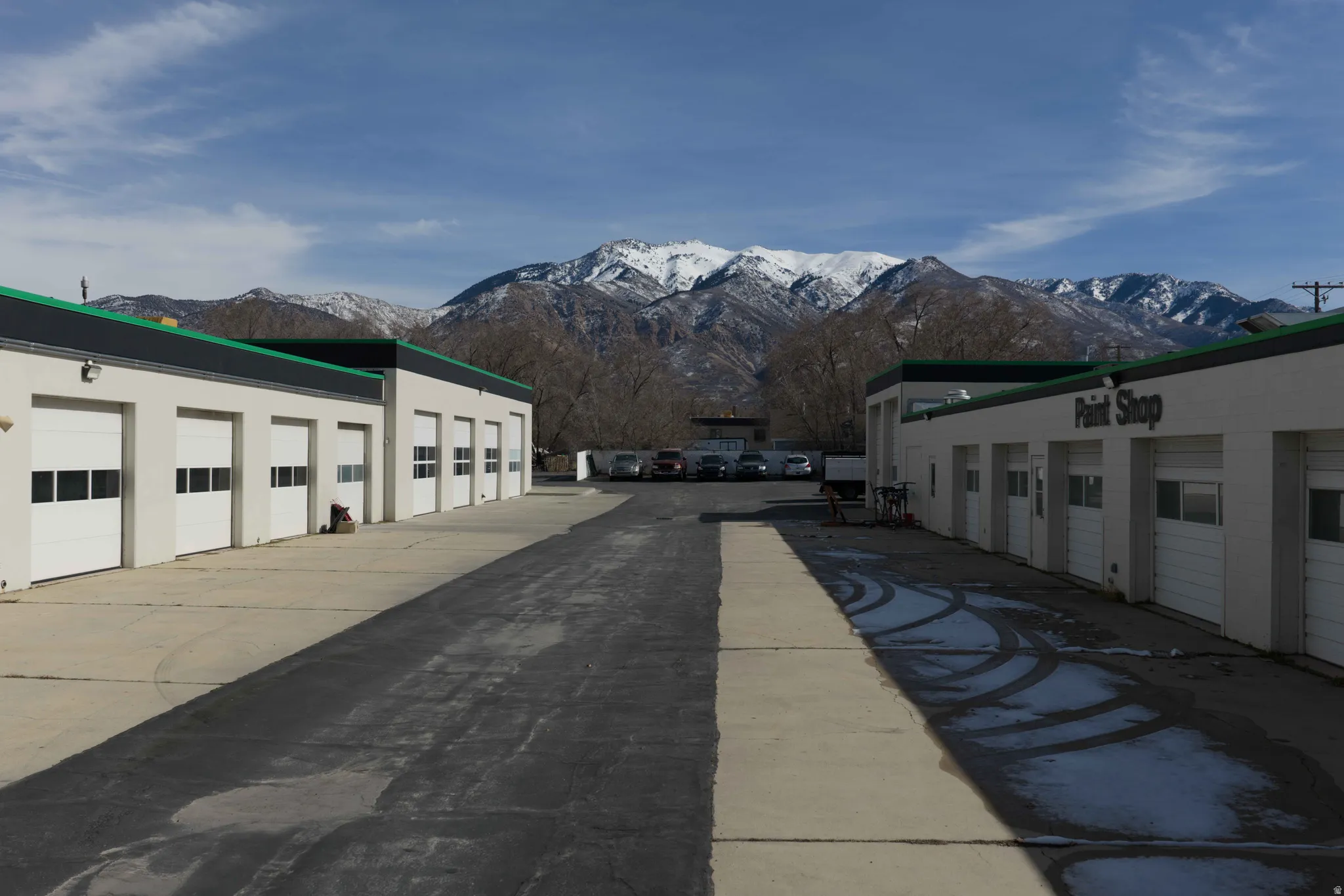 View of concrete driveway featuring a mountain view and community garages