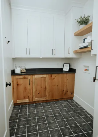 Laundry room with cabinet space, washer hookup, and dark tile patterned floors