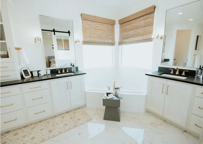 Full bath featuring a bath, two vanities, connected bathroom, recessed lighting, and light marble finish floors