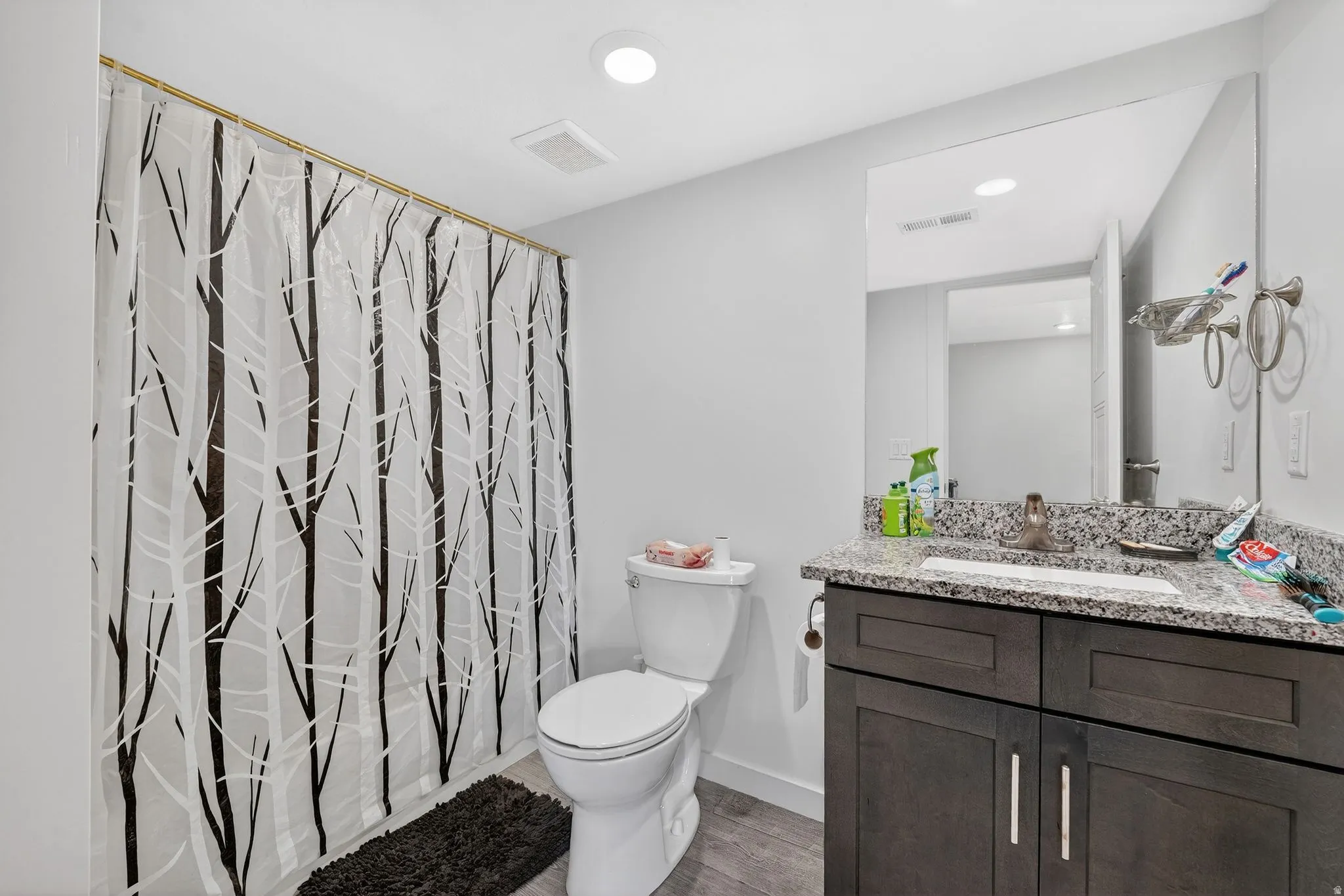 Bathroom with vanity, recessed lighting, wood finished floors, and shower / tub combo with curtain