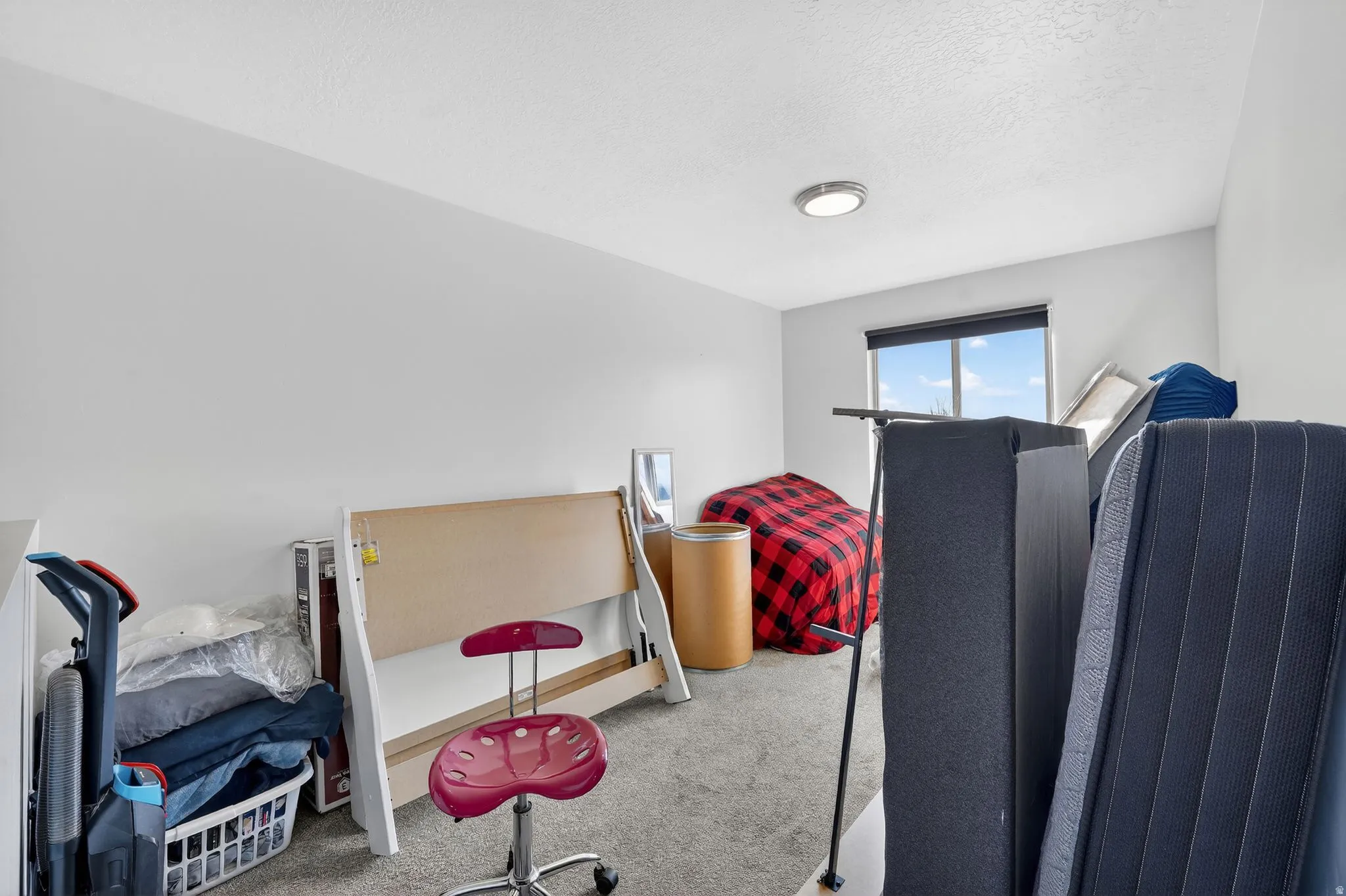 Carpeted bedroom with a textured ceiling