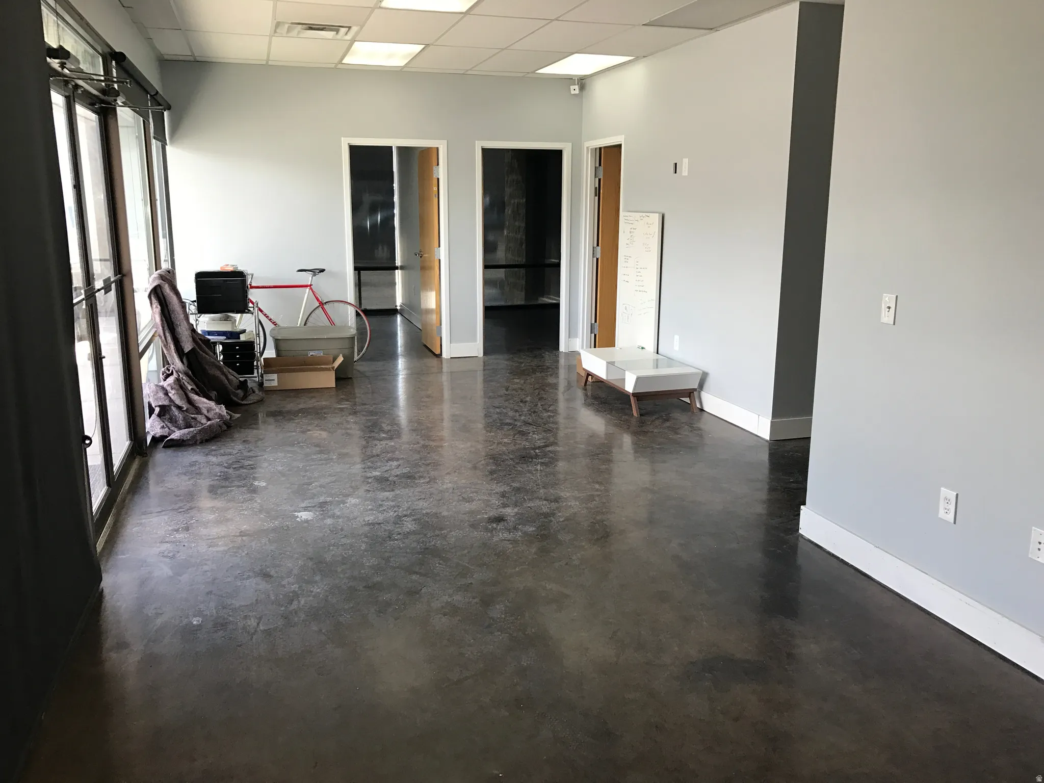 Empty room featuring a paneled ceiling and concrete flooring